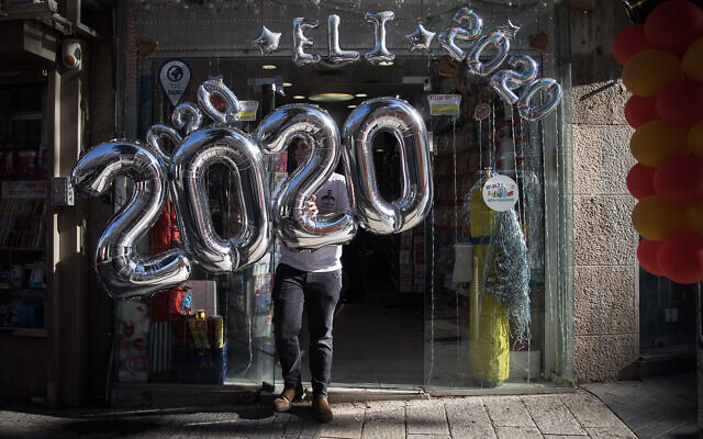 Des ballons 2020 suspendus à une devanture de magasin à Jérusalem à la veille du Nouvel An, le 31 décembre 2019. (Crédit : Hadas Parush / Flash90)