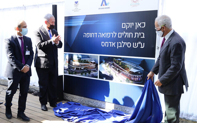 La cérémonie avant la construction d’un nouveau service de soins d'urgence de l'hôpital Ichilov, avec Ronni Gamzu, Benjamin Netanyahu et Sylvan Adams. (Crédit : GPO) La cérémonie avant la construction d’un nouveau service de soins d'urgence de l'hôpital Ichilov, avec Ronni Gamzu, Benjamin Netanyahu et Sylvan Adams. (Crédit : GPO)