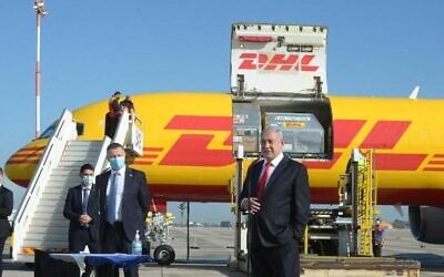 Le Premier ministre Benjamin Netanyahu assistant à l'arrivée d'un avion cargo de DHL transportant le premier lot de vaccins Pfizer, à l'aéroport Ben Gurion le 9 décembre 2020. (Crédit : Marc Israel Sellem/POOL)