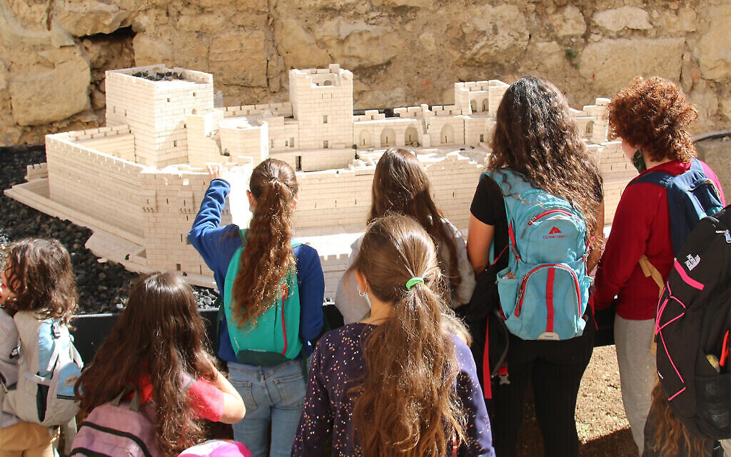 Des visiteurs regardent la reproduction de la citadelle de la Vieille Ville au musée de la Tour de David de Jérusalem. (Crédit : Shmuel Bar-Am)