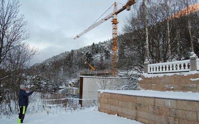 Terje Lien, le plus proche voisin d'Utoyakaia, en Norvège, le 5 janvier 2021, indique le site de construction, où un mémorial est en cours de construction pour honorer les 77 personnes qui ont été tuées le 22 juillet 2011 par l'extrémiste de droite norvégien Anders Behring Breivik, dont 69 sur l'île voisine d'Utoya. (Crédit : Pierre-Henry DESHAYES / AFP) Terje Lien, le plus proche voisin d'Utoyakaia, en Norvège, le 5 janvier 2021, indique le site de construction, où un mémorial est en cours de construction pour honorer les 77 personnes qui ont été tuées le 22 juillet 2011 par l'extrémiste de droite norvégien Anders Behring Breivik, dont 69 sur l'île voisine d'Utoya. (Crédit : Pierre-Henry DESHAYES / AFP)