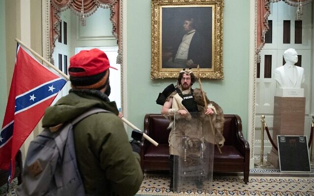 Aaron Mostofsky (en fourrure) et un manifestant avec le drapeau confédéré dans la rotonde du Capitole américain, le 6 janvier 2021, à Washington. (Crédit : Saul Loeb / AFP)