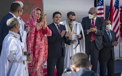 Le ministre marocain des affaires étrangères Nasser Bourita (C) et David Schenker, secrétaire d'État adjoint américain aux affaires du Proche-Orient - qui porte une robe traditionnelle pour hommes appelée "Darraa" - (au centre) posent avec d'autres responsables pour une photo après leur rencontre à Dakhla, au Sahara occidental sous administration marocaine, le 10 janvier 2021. (Crédit : Fadel SENNA / AFP)