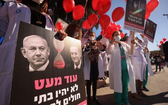 Des membres du personnel médical lors d'une manifestation devant le bureau du Premier ministre israélien Benjamin Netanyahu à Jérusalem, le 21 janvier 2021. (Emmanuel DUNAND / AFP) Des membres du personnel médical lors d'une manifestation devant le bureau du Premier ministre israélien Benjamin Netanyahu à Jérusalem, le 21 janvier 2021. (Emmanuel DUNAND / AFP)