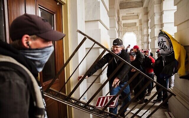 Un membre d'une foule pro-Trump défonce une entrée du Capitole pour tenter d'y accéder le 6 janvier 2021 à Washington, DC. Une foule pro-Trump a pris d'assaut le Capitole, brisant des fenêtres et s'affrontant avec des policiers. (Crédit : Jon Cherry/Getty Images/AFP) Un membre d'une foule pro-Trump défonce une entrée du Capitole pour tenter d'y accéder le 6 janvier 2021 à Washington, DC. Une foule pro-Trump a pris d'assaut le Capitole, brisant des fenêtres et s'affrontant avec des policiers. (Crédit : Jon Cherry/Getty Images/AFP)