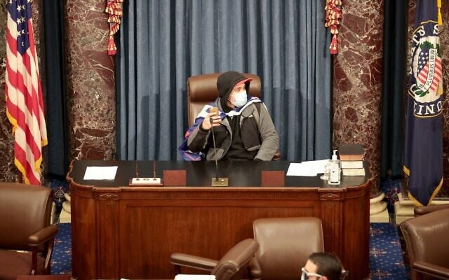 Un manifestant assis dans la salle du Sénat le 6 janvier 2021 à Washington, DC. Le Congrès a tenu une session conjointe aujourd'hui pour ratifier la victoire du Collège électoral 306-232 du Président élu Joe Biden sur le Président Donald Trump. Les manifestants pro-Trump ont pris d'assaut le Capitole américain après les manifestations de masse dans la capitale du pays. (Crédit : Gagner McNamee/Getty Images/AFP) Un manifestant assis dans la salle du Sénat le 6 janvier 2021 à Washington, DC. Le Congrès a tenu une session conjointe aujourd'hui pour ratifier la victoire du Collège électoral 306-232 du Président élu Joe Biden sur le Président Donald Trump. Les manifestants pro-Trump ont pris d'assaut le Capitole américain après les manifestations de masse dans la capitale du pays. (Crédit : Gagner McNamee/Getty Images/AFP)