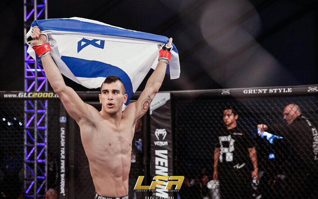 Natan Levy montre fièrement un drapeau israélien avant ses matchs. (Amy Kaplan/ via JTA)