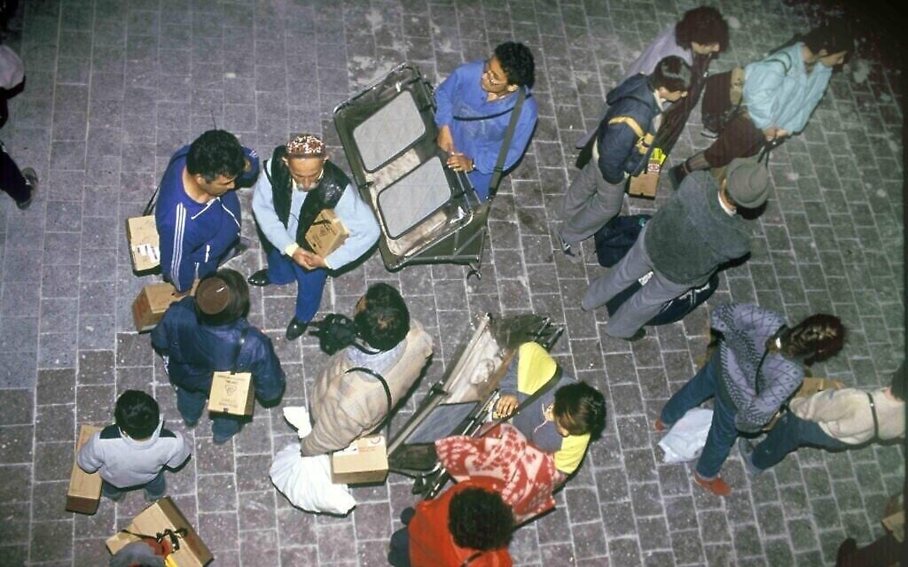 Des Israéliens tenant des boîtes en carton qui renferment des masques à gaz par crainte d'une attaque à l'arme chimique, pendant la première guerre du Golfe de 1991. (Noam Wind / Archives du ministère de la Défense)