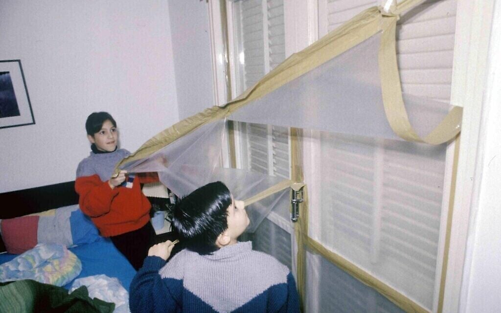 Des enfants israéliens retirent des bâches de protection en plastique qui étaient destinées à les protéger en cas d’attaque chimique par des missiles Scud pendant la première guerre du Golfe de 1991. (Michael Tzarfati / Archives du ministère de la Défense)