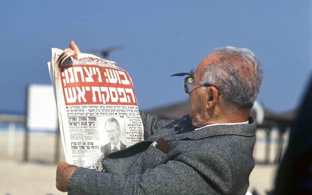 Un homme sur la plage avec un journal dont le titre est : « Bush : Nous avons gagné ; un cessez-le-feu », en référence à la fin de la première guerre du Golfe de 1991. (Archives du ministère de la Défense)