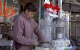 Omar, un adolescent jordanien de 14 ans, répare un chauffage au kérosène dans un atelier où il travaille à Amman le 10 janvier 2021. (Crédit : Khalil MAZRAAWI / AFP)