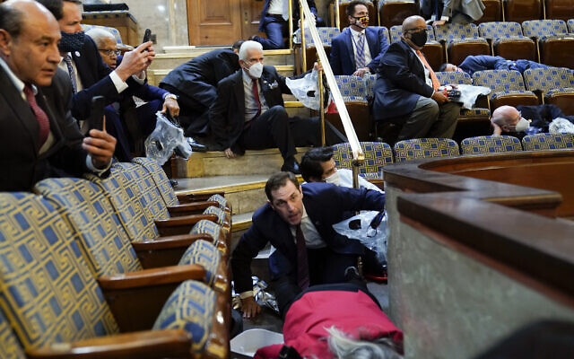 Des gens s'abritent dans la galerie de la Chambre des représentants alors que des manifestants tentent de s'introduire dans l'hémicycle du Capitole américain, le mercredi 6 janvier 2021, à Washington. (AP Photo/Andrew Harnik) Des gens s'abritent dans la galerie de la Chambre des représentants alors que des manifestants tentent de s'introduire dans l'hémicycle du Capitole américain, le mercredi 6 janvier 2021, à Washington. (AP Photo/Andrew Harnik)