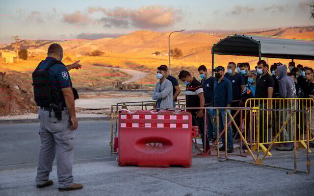 Illustration : des travailleurs palestiniens font la queue pour franchir un point de contrôle à l'entrée de Cisjordanie de Maale Adumim, près de Jérusalem, le 30 juin 2020. (Crédit : AP Photo/Oded Balilty, Archive) Illustration : des travailleurs palestiniens font la queue pour franchir un point de contrôle à l'entrée de Cisjordanie de Maale Adumim, près de Jérusalem, le 30 juin 2020. (Crédit : AP Photo/Oded Balilty, Archive)