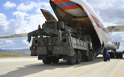 Des véhicules et équipements militaires, ainsi que des pièces des systèmes de défense aérienne S-400, sont déchargés d’un avion de transport russe à l’aéroport militaire de Murted à Ankara, en Turquie, le 12 juillet 2019. (Crédit : Ministère turc de la Défense/AP)