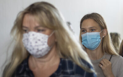 Le top model israélien Bar Refaeli, à droite, et sa mère, Tzipi Rafaieli, portent des masques, quittent une salle d'audience à Tel Aviv, le 13 septembre 2020 (Crédit : AP Photo/Ariel Schalit, Pool)