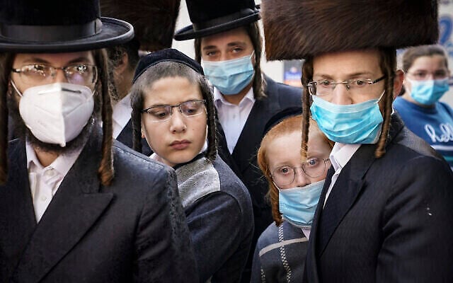 Illustration : Des membres de la communauté juive orthodoxe se rassemblent autour d'un journaliste alors qu'il mène une interview à un coin de rue, le 7 octobre 2020, dans le quartier de Borough Park de l'arrondissement de Brooklyn à New York. (AP Photo/John Minchillo)