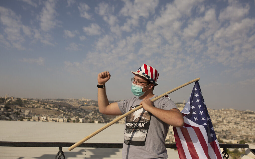Un supporter israélien du président américain Donald Trump porte un chapeau aux couleurs du drapeau américain lors d'un rassemblement pour sa réélection, sur une promenade surplombant Jérusalem, le 27 octobre 2020. (Crédit : AP Photo/Maya Alleruzzo) Un supporter israélien du président américain Donald Trump porte un chapeau aux couleurs du drapeau américain lors d'un rassemblement pour sa réélection, sur une promenade surplombant Jérusalem, le 27 octobre 2020. (Crédit : AP Photo/Maya Alleruzzo)