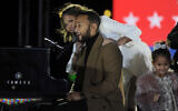 L'artiste John Legend, sa femme Chrissy Teigen et leur fille Luna saluent la foule lors d'un meeting en drive-in avec le candidat démocrate à la vice-présidence Kamala Harris, le 2 novembre 2020 à Philadelphie. (Crédit : AP Photo/Michael Perez)