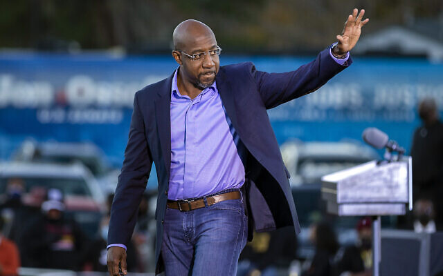 Le candidat démocrate au sénat  Raphael Warnock salue ses partisans pendant un rassemblement organisé à Savannah, en Georgie, le 3 janvier 2021. (Crédit : AP Photo/Stephen B. Morton)