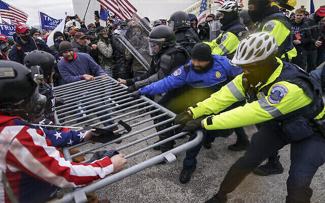 Alors que le Congrès s'apprête à affirmer la victoire du président élu Joe Biden, des milliers de personnes se sont rassemblées pour montrer leur soutien au président Donald Trump et à ses accusations de fraude électorale. Des partisans de Trump tentent de franchir une barrière policière au Capitole de Washington, le 6 janvier 2021. (Crédit : John Minchillo/AP) Alors que le Congrès s'apprête à affirmer la victoire du président élu Joe Biden, des milliers de personnes se sont rassemblées pour montrer leur soutien au président Donald Trump et à ses accusations de fraude électorale. Des partisans de Trump tentent de franchir une barrière policière au Capitole de Washington, le 6 janvier 2021. (Crédit : John Minchillo/AP)