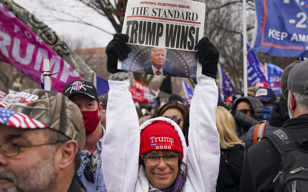 Une sympathisante du président Donald Trump brandit un journal avec une fausse manchette, le mercredi 6 janvier 2021 à Washington, peu avant l'assaut contre le Capitole américain. (AP Photo/John Minchillo) Une sympathisante du président Donald Trump brandit un journal avec une fausse manchette, le mercredi 6 janvier 2021 à Washington, peu avant l'assaut contre le Capitole américain. (AP Photo/John Minchillo)