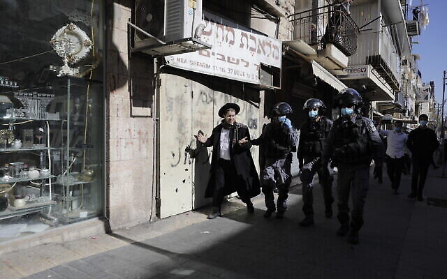 La police israélienne arrête un homme ultra-orthodoxe à Jérusalem, le 24 janvier 2021. (Crédit : AP Photo/Sebastian Scheiner)