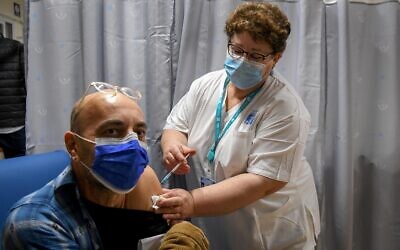 Un enseignant israélien reçoit un vaccin contre la COVID-19 au centre médical Shamir de Be'er Ya'akov, le 30 décembre 2020. (Crédit : Avi Dishi / Flash90)