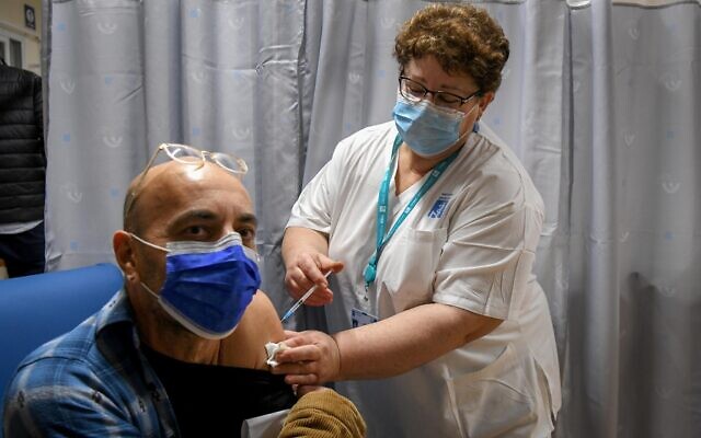 Un enseignant israélien reçoit un vaccin contre la COVID-19 au centre médical Shamir de Be'er Ya'akov, le 30 décembre 2020. (Crédit : Avi Dishi / Flash90)
