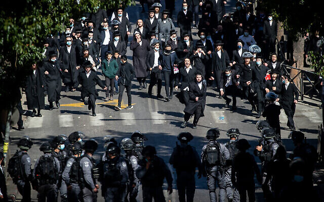 La police affrontant des hommes haredim pour faire respecter les restrictions relatives au coronavirus dans le quartier de Mea Shearim, à Jérusalem, le 24 janvier 2021. (Crédit : Yonatan Sindel/Flash90)