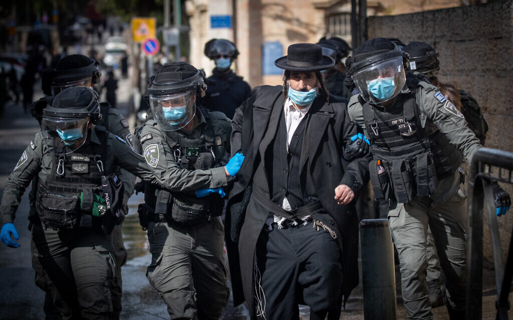 La police affronte des hommes haredim pour faire respecter les restrictions contre le coronavirus, à Jérusalem, le 26 janvier 2021. (Crédit : Yonatan Sindel / Flash90) La police affronte des hommes haredim pour faire respecter les restrictions contre le coronavirus, à Jérusalem, le 26 janvier 2021. (Crédit : Yonatan Sindel / Flash90)