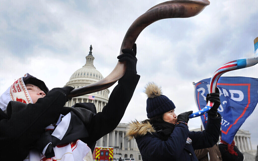 Deux femmes, dont une portant un talith, sonnent le shofar lors des émeutes au Capitole, le 6 janvier 2021. (Lloyd Wolf via JTA)