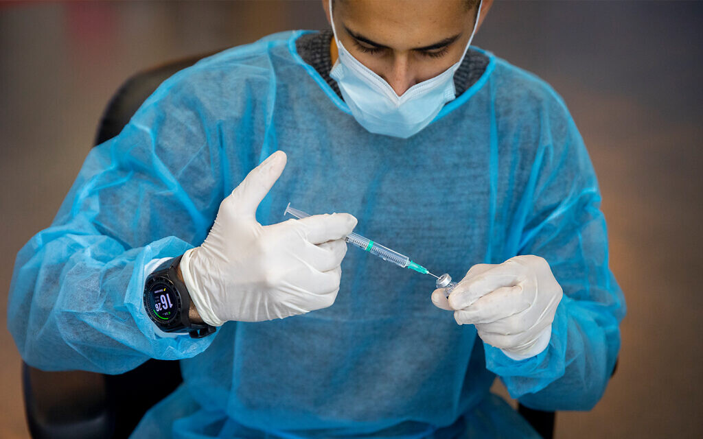 Un employé du secteur de la santé prépare un vaccin contre la COVID-19 dans un centre de vaccination de Jérusalem, le 4 janvier 2021. (Crédit : Olivier Fitoussi/Flash90)