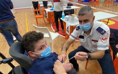 Un jeune garçon reçoit le vaccin contre le coronavirus au centre de vaccination du Centre national de Shalva, à Jérusalem, le 3 janvier 2021. (Crédit : Shalva)