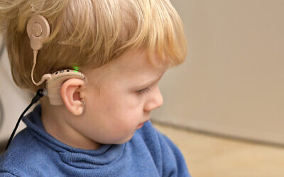 Un enfant avec des appareils auditifs. (Crédit : icarmen13 via iStock by Getty Images)