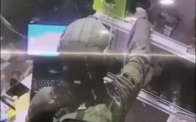 Un soldat de Tsahal vole un paquet de cigarettes dans un magasin palestinien, comme le montre les images de vidéosurveillance, le 27 décembre 2020. (Capture d'écran : Twitter) Un soldat de Tsahal vole un paquet de cigarettes dans un magasin palestinien, comme le montre les images de vidéosurveillance, le 27 décembre 2020. (Capture d'écran : Twitter)