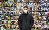 Un vendeur portant un masque se tient devant des titres de jeux vidéo sur un mur, dans un magasin de jeux et de consoles sur le marché central de la capitale iranienne, Téhéran, le 24 janvier 2021. (Crédit : ATTA KENARE / AFP)