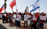 Un groupe de militants birmans résidant en Israël brandissent (de gauche à droite) le drapeau historique de la Birmanie (jusqu'en 1974), le drapeau du parti de la Ligue nationale pour la démocratie de la dirigeante évincée Aung San Suu Kyi, et le drapeau d'Israël, lors d'une manifestation devant l'ambassade du pays dans la ville côtière méditerranéenne de Tel Aviv, le 3 février 2021. (JACK GUEZ / AFP)