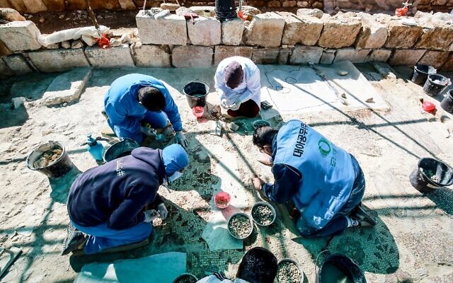 Des travailleurs employés dans le cadre d'un projet pilote mené par l'agence culturelle des Nations unies, l'UNESCO, restaurent le 9 février 2021 le sol en mosaïque d'un ancien complexe d'églises, dans la petite ville de Rihab, à 70 kilomètres au nord d'Amman. (Crédit : Khalil MAZRAAWI / AFP)