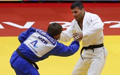 Le judoka de Mongolie d'origine iranienne Saeid Mollaei (blanc) affronte le judoka d'Ouzbékistan Sharofiddin Boltaboev lors de la finale de la catégorie masculine des moins de 81 kg du Grand Chelem de Tel Aviv 2021, dans la ville de Tel Aviv, le 19 février 2021. (JACK GUEZ / AFP)