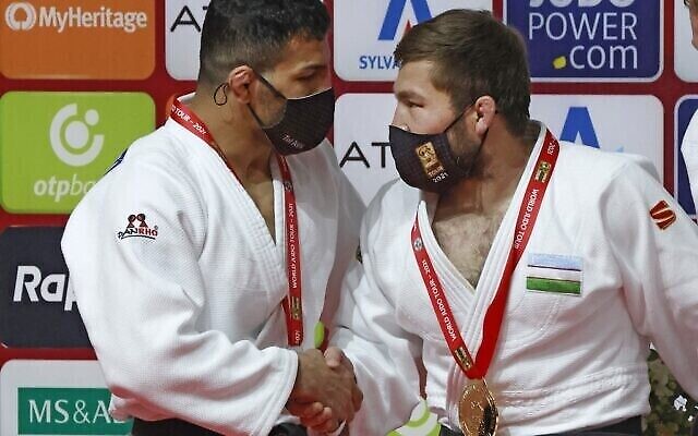 Le judoka de Mongolie d'origine iranienne Saeid Mollaei (à gauche), qui porte la médaille d'argent, salue le médaillé d'or ouzbek Sharofiddin Boltaboev après la finale de la catégorie masculine des moins de 81 kg du Grand Chelem 2021 de Tel Aviv, le 19 février 2021. (JACK GUEZ / AFP)