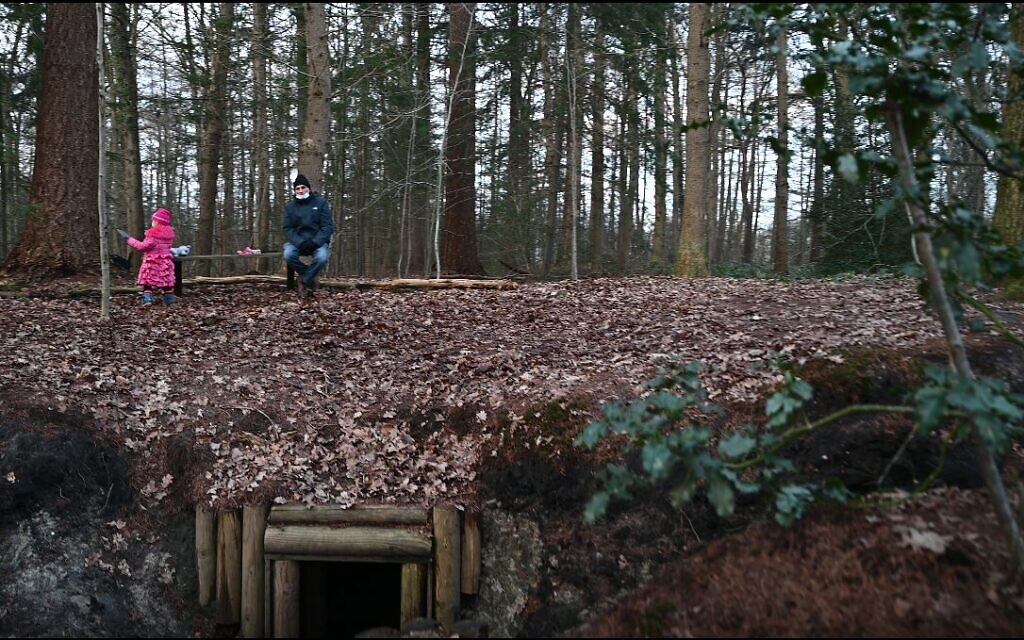 Une petite fille néerlandaise jour en compagnie de son grand-père au-dessus d'une reconstruction d'abri qui accueillait les Juifs vivant dans la clandestinité à Nieuwlande, aux Pays-Bas, le 25 janvier 2021. Crédit : Cnaan Liphshiz/ JTA)
