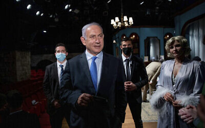Le Premier ministre Benjamin Netanyahu rencontre l'actrice Carmit Mesilati Kaplan, à droite, lors d'une visite au théâtre Khan avant la réouverture du secteur culturel, à Jérusalem, le 23 février 2021. (Crédit : Ohad Zwigenberg / Pool Photo via AP)