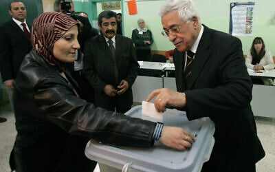 Le président de l'Autorité palestinienne, Mahmoud Abbas, (à droite), vote lors du scrutin pour les élections locales dans la ville de Ramallah en Cisjordanie le 15 décembre 2005. (AP Photo/Muhammed Muheisen/File)