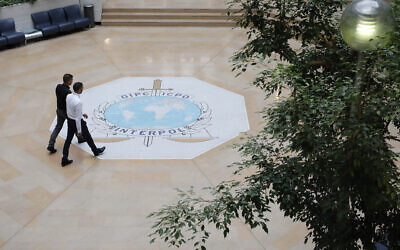 Des gens marchent sur le logo d'Interpol à Lyon, dans le centre de la France, le 8 novembre 2018. (AP Photo/Laurent Cipriani)