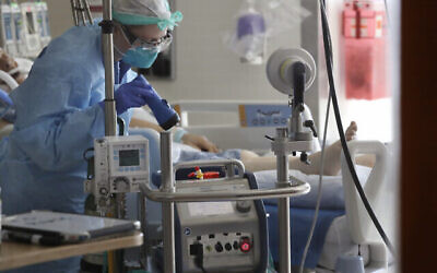 Photo d'illustration : Un infirmier surveille une machine ECMO (oxygénation par membrane extracorporelle) reliée à un malade à l'hôpital Harborview de Seattle, le 8 mai 2020. (Crédit : Elaine Thompson/AP)