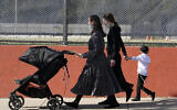 Des jeunes femmes ultra-orthodoxes à Borough Park, pendant, Soukkot, le 4 octobre 2020. (Crédit : AP/Kathy Willens)