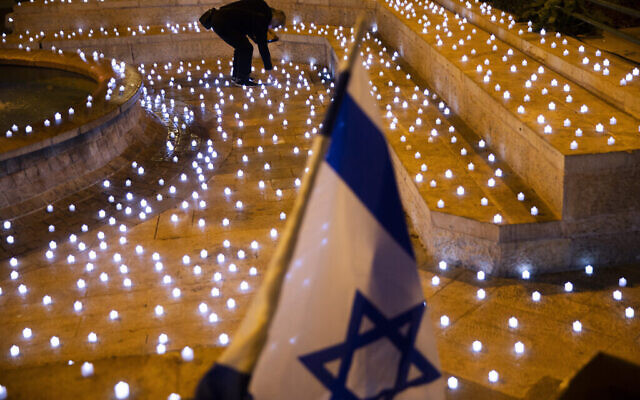 Un homme allume des bougies LED dans un mémorial pour les victimes israéliennes de la COVID-19, à Jérusalem, le dimanche 8 novembre 2020. (Crédit : AP Photo / Oded Balilty) Un homme allume des bougies LED dans un mémorial pour les victimes israéliennes de la COVID-19, à Jérusalem, le dimanche 8 novembre 2020. (Crédit : AP Photo / Oded Balilty)