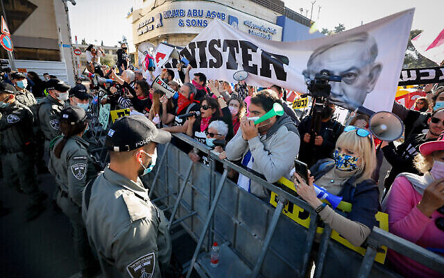 Des manifestants anti-Netanyahu devant le tribunal de district de Jérusalem, alors que le Premier ministre Benjamin Netanyahu arrive pour son procès au tribunal de district, le 08 février 2021. (Crédit : Olivier Fitoussi/Flash90)