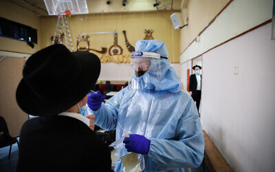 Un personnel soignant fait un test au coronavirus sur un ultra-orthodoxe à Safed, le 10 février 2021. (Crédit : David Cohen/Flash90)
