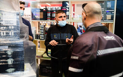 Des policiers et des inspecteurs de la municipalité de Bat Yam font respecter le confinement au centre commercial de Bat Yam, qui a été partiellement ouvert contre la réglementation gouvernementale, le 11 février 2021. (Avshalom Sassoni / Flash90)